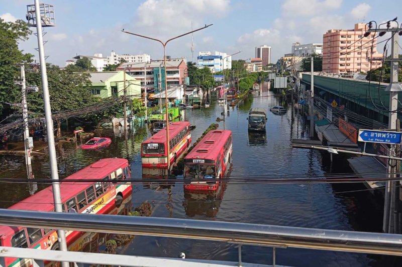 Passenger buses and trucks run on flooded Nawamin Road in Bang Kapi district, Bangkok, on Wednesday morning. Bang Kapi district office