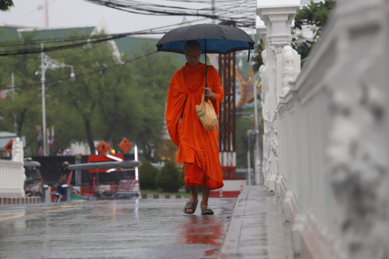 A monk walks in the rain in Bangkok on Sept 26. (Photo: Apichart Jinakul)