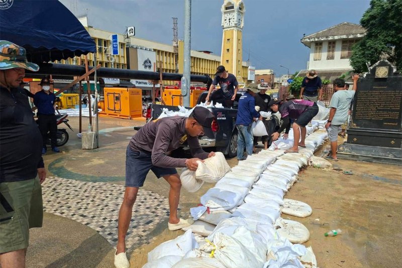 Municipal workers and soldiers use sandbags to reinforce the existing flood barriers at Nonthaburi pier in Muang district on Wednesday. (Photo: Nonthaburi Municipality)