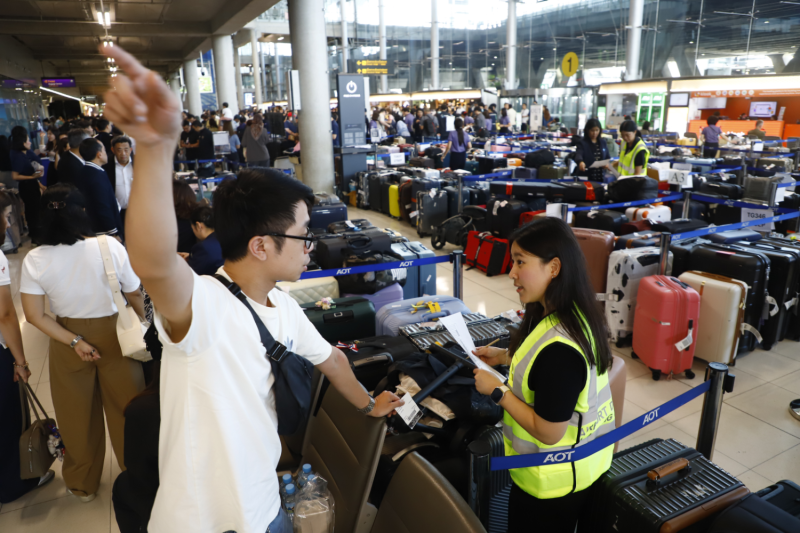 A passenger talks to a staff member at Suvarnabhumi airport, where about 10,000 pieces of luggage remained uncleared, on Tuesday. (Photo: Nutthawat Wichieanbut)