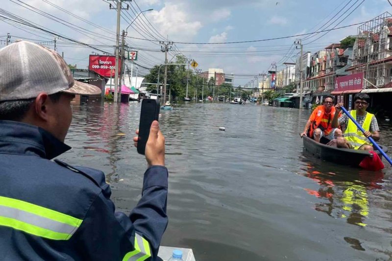 Commuters use boats in Lat Krabang district in eastern Bangkok, where water levels remained high in some areas on Wednesday. (Photo: Lat Krabang district office)