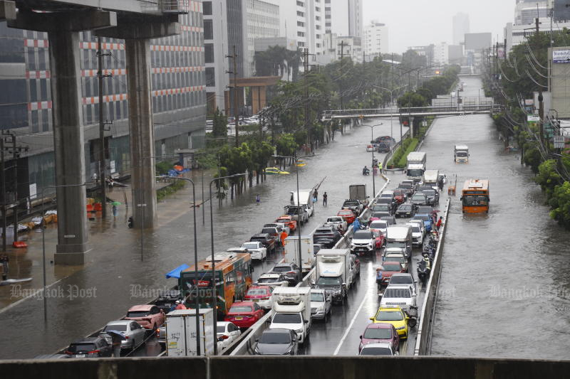 The scene on Lat Phrao Road following continuous heavy rainfall, which has triggered widespread flash flooding. Floodwaters have inundated the roadway, forcing cars, public buses and motorcycles to navigate the deep waters with difficulty. (Photo: Nutthawat Wichieanbut)