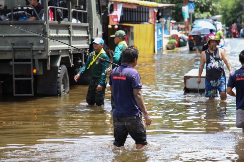 Soldiers and volunteers provide relief items to residents affected by flooding at Soi Nawamin 24 in Bangkok on Sept 29. (Photo: Varuth Hirunyatheb)