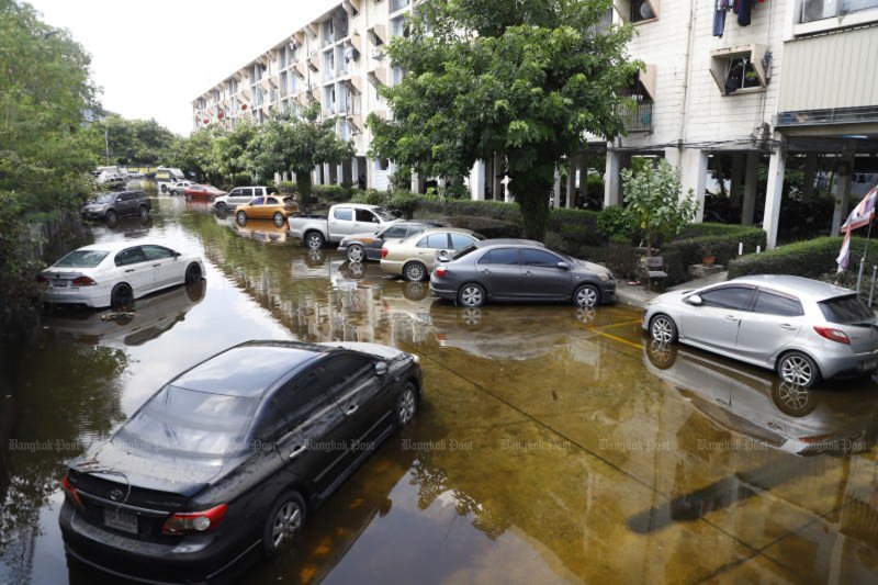 Cars sit in lingering floodwater at Khlong Chan Housing Estate in Bangkok's Bang Kapi district on Thursday as water levels continued to recede after flooding eased. (Photo: Nutthawat Wichieanbut)