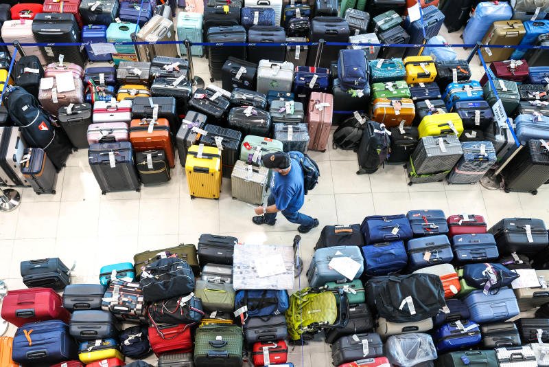 A passenger searches for his delayed baggage from Thai Airways International flights at Suvarnabhumi Airport, after heavy rain and flooding disrupted the airline's ground operations, on Tuesday. (Photo: Reuters)