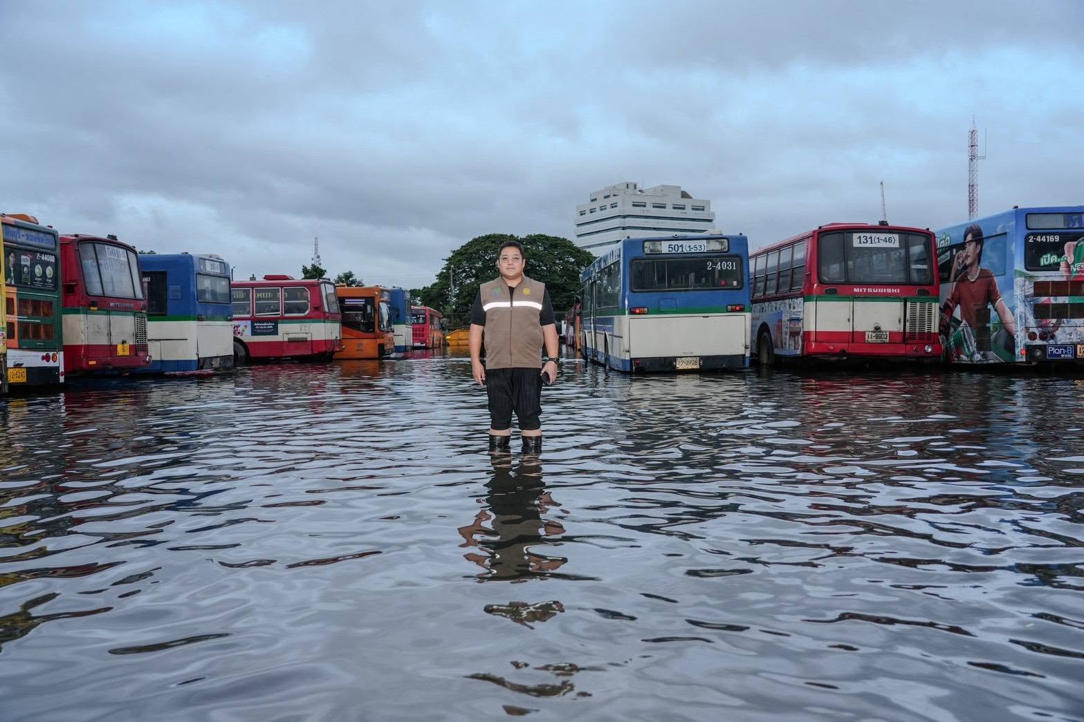 Kittikan Chomdoung Charuworapolkul, director of the Bangkok Mass Transit Authority (BMTA), stands in floodwaters among the remaining veteran passenger buses. (Photo: Kittikan Chomdoung Charuworapolkul)