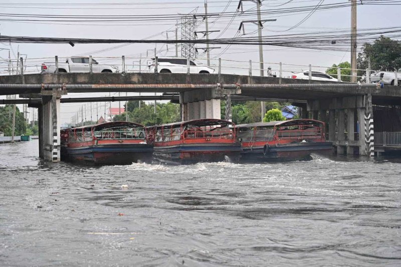 Moored motorboats gun their engines, helping propel the flow along Khlong Prawet Burirom in Lat Krabang district, Bangkok, on Saturday. (Photo: BMA)