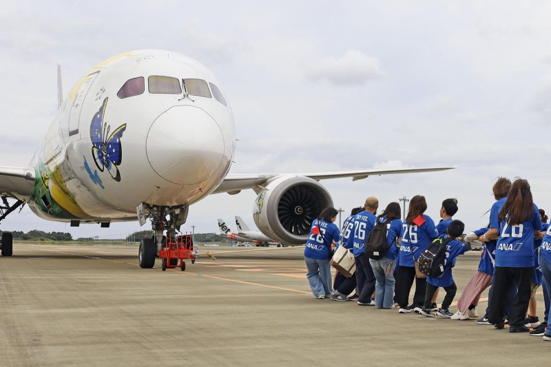 People tow an aircraft at Narita airport in Chiba prefecture on Sunday. (Photo: Kyodo)