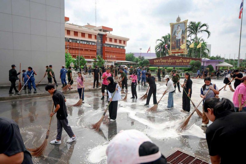 Ramkhamhaeng University staff, students and volunteers take part in a post-flood clean-up around the campus in Bang Kapi district on Monday. Ramkhamhaeng University