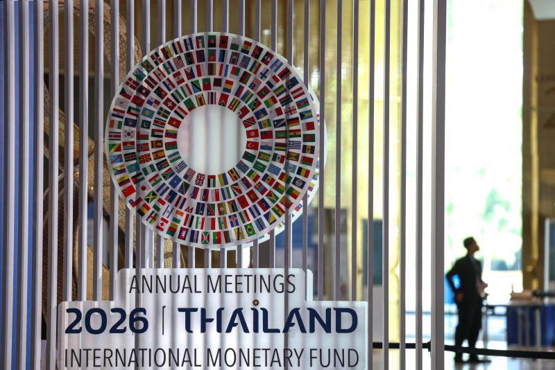 A person stands next to the logo of the 2026 IMF-World Bank Annual Meetings, ahead of the meeting at Queen Sirikit National Convention Center on Friday. (Photo: Reuters)