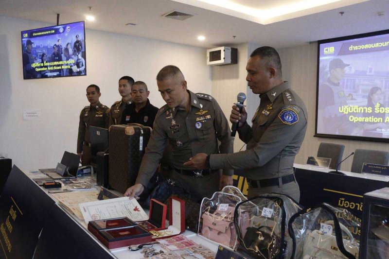 Pol Lt Gen Jirabhop Bhuridej, deputy director of the Anti Cyber Scam Centre (ACSC), and Pol Lt Gen Natthasak Chaowanasai, commissioner of the Central Investigation Bureau (CIB), examine seized items during a press conference on a raid of 27 locations that netted assets worth more than 500 million baht linked to transnational scams and money laundering. Wassayos Ngamkham