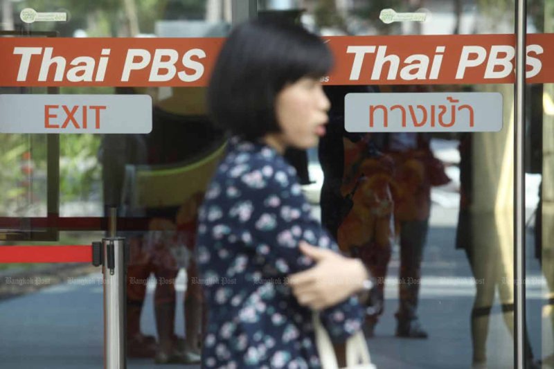 A woman walks past the Thai PBS office on Vibhavadhi Road in Bangkok. (File photo)