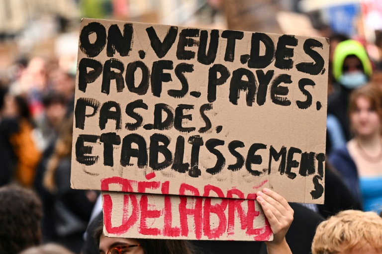 “We want teachers to be paid, not dilapidated schools”, says a poster held during a recent protest in France. (Photo: AFP)