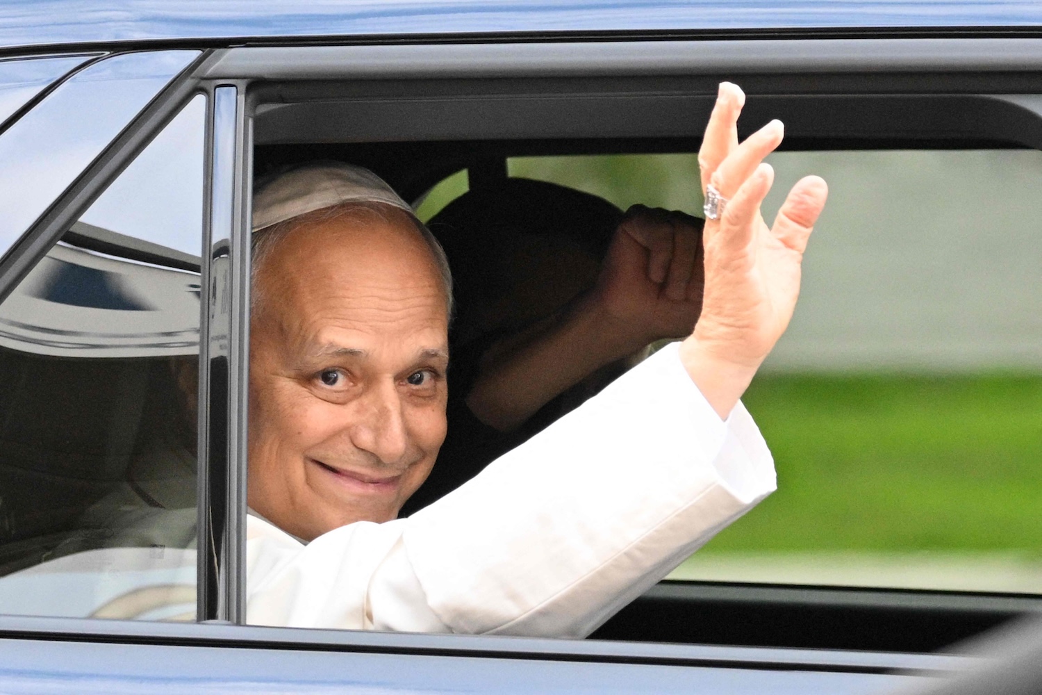 Pope Leo XIV waves from a car taking him back to the Vatican to continue his recovery, on Oct 17, 2026. (Photo: AFP)