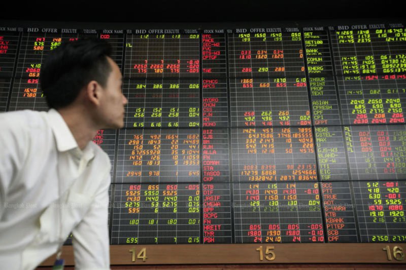 A trader watches the board at a stock brokerage on Sathon Road in Bangkok. (Bangkok Post file photo)
