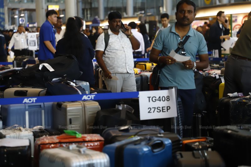 Passengers wait to claim their baggage as thousands of suitcases wait to be handled and collected at Suvarnabhumi airport after floods in late September caused flight delays and staff shortages for Thai Airways International. (Photo: Nutthawat Wichieanbut)