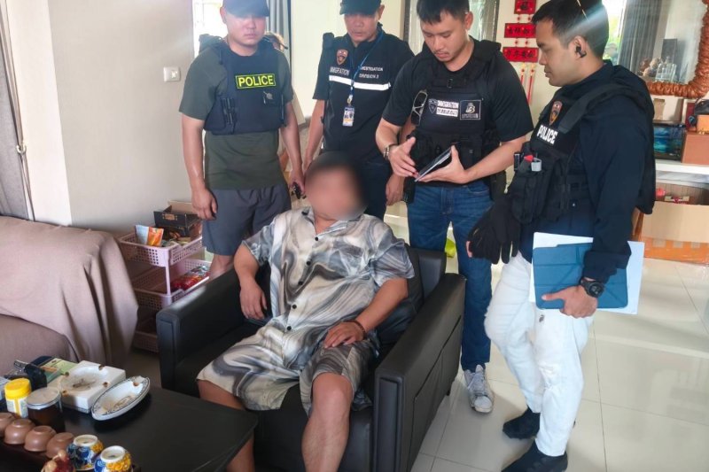 Police question the 37-year-old Chinese fugitive accused of overseeing a major mule account network at a house in the Ramkhamhaeng area of Saphan Sung district in Bangkok on Saturday. (Photo: Supplied/ Wassayos Ngamkham)