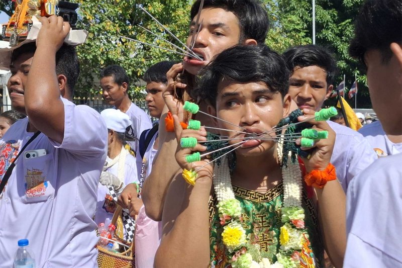 'Spirit mediums' perform piercing in a deity parade in Phuket on Sunday. (Photos: Achadthaya Chuenniran