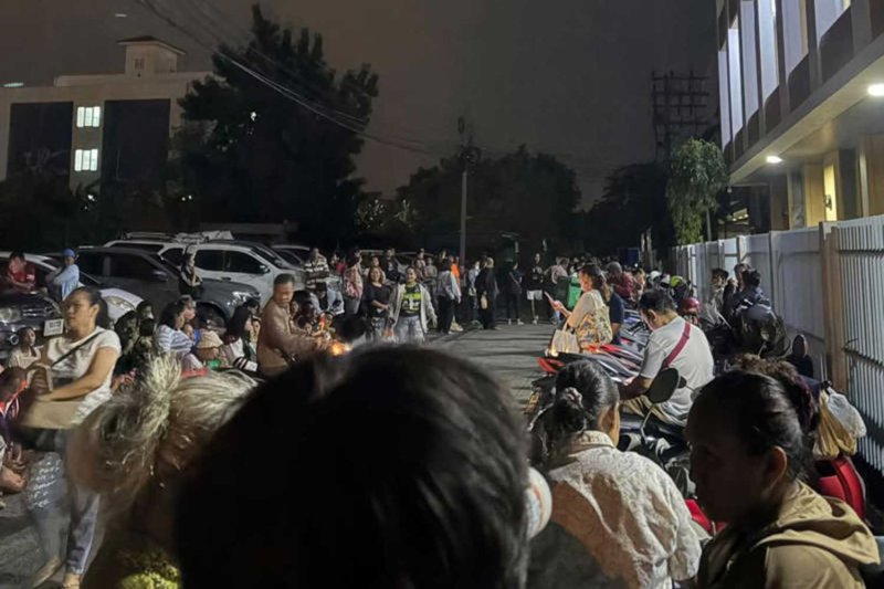A screen capture shows flood victims queuing before dawn outside Sai Mai district office on Saturday to submit compensation claims.