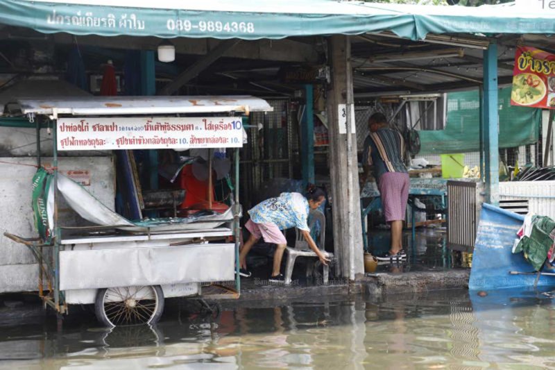 Vendors check their flood-damaged stalls in the compound of Khlong Chan Flats in Bang Kapi district, Bangkok, on Oct 1. (Photo: Nutthawat Wichieanbut)