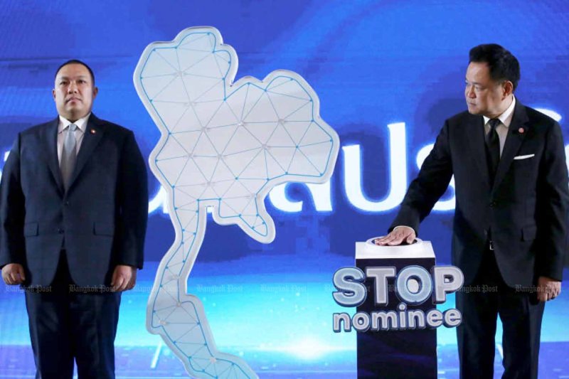 Prime Minister and Interior Minister Anutin Charnvirakul presses the “STOP Nominee” button as he launches a campaign to crack down on foreigners’ illegal land ownership in Thailand at Government House on Monday. Deputy Interior Minister Polapee Suwunchwee, left, who oversees the Department of Lands, was also present. (Photo: Chanat Katanyu)