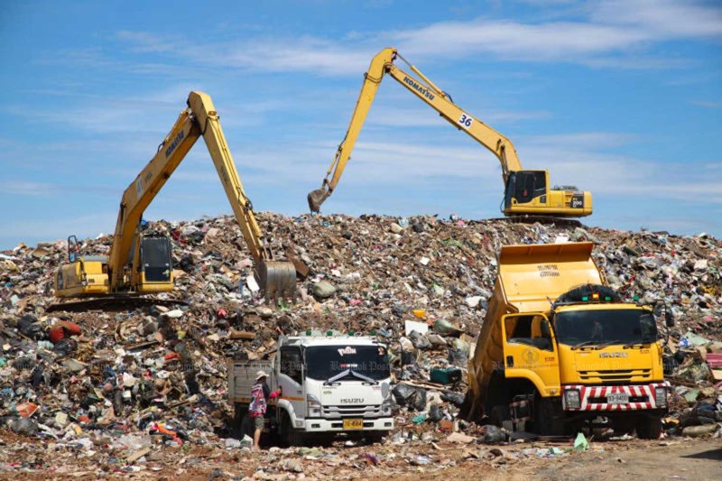City workers use excavators to level flood waste dumped by residents at a collection point on Srinakarin-Rom Klao Road in Bangkok’s Lat Krabang district on Monday. Varuth Hirunyatheb