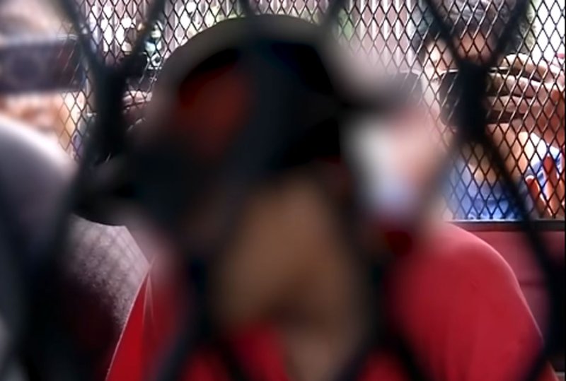 Natthanon, 19, a motorcyclist who smashed a car windscreen and punched a 27-year-old woman in the face during a road rage incident in Bangkok on Thursday evening, is escorted to a police vehicle to be taken to court, where he was remanded in custody, on Saturday. (Screengrab from TV)
