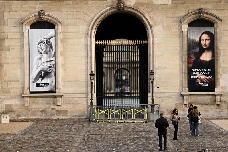 People stand in front of the Louvre Museum, which is closed all day due to the fears of renewed turmoil in Paris ahead of nationwide protests, on Saturday. (Photo: Reuters)