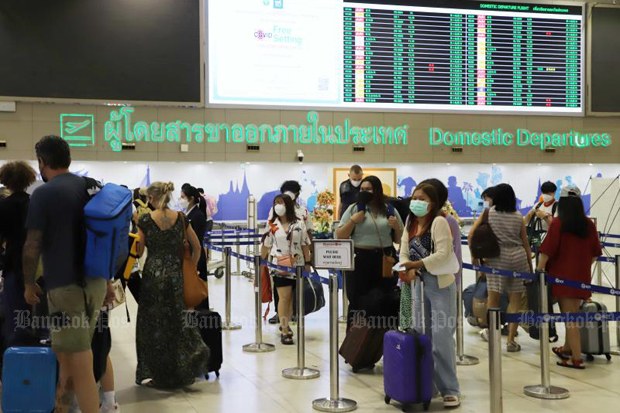 Travellers on domestic flights queue to check-in at Don Mueang airport. (Photo: Apichit Jinakul)