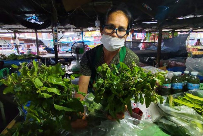 A vegetable vendor displays holy basil leaves at her stall in a market in Phimai district, Nakhon Ratchasima on Oct 23. (Photo: Prasit Tangprasert)