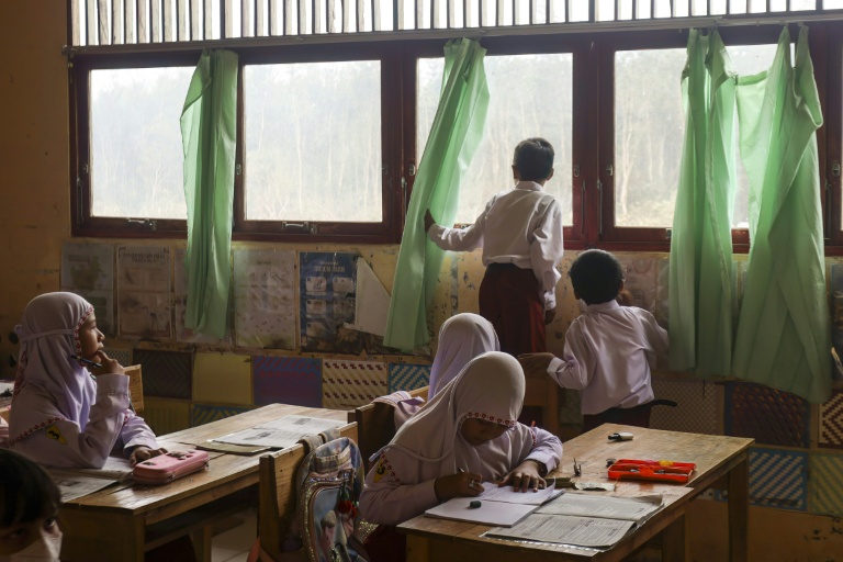 A boy looks out of a classroom window before students at the elementary school were sent home early due to thick smoke from a peat fire behind their school at Alalak village in Barito Kuala Regency on South Kalimantan on October 28, 2026. (Photo: AFP)