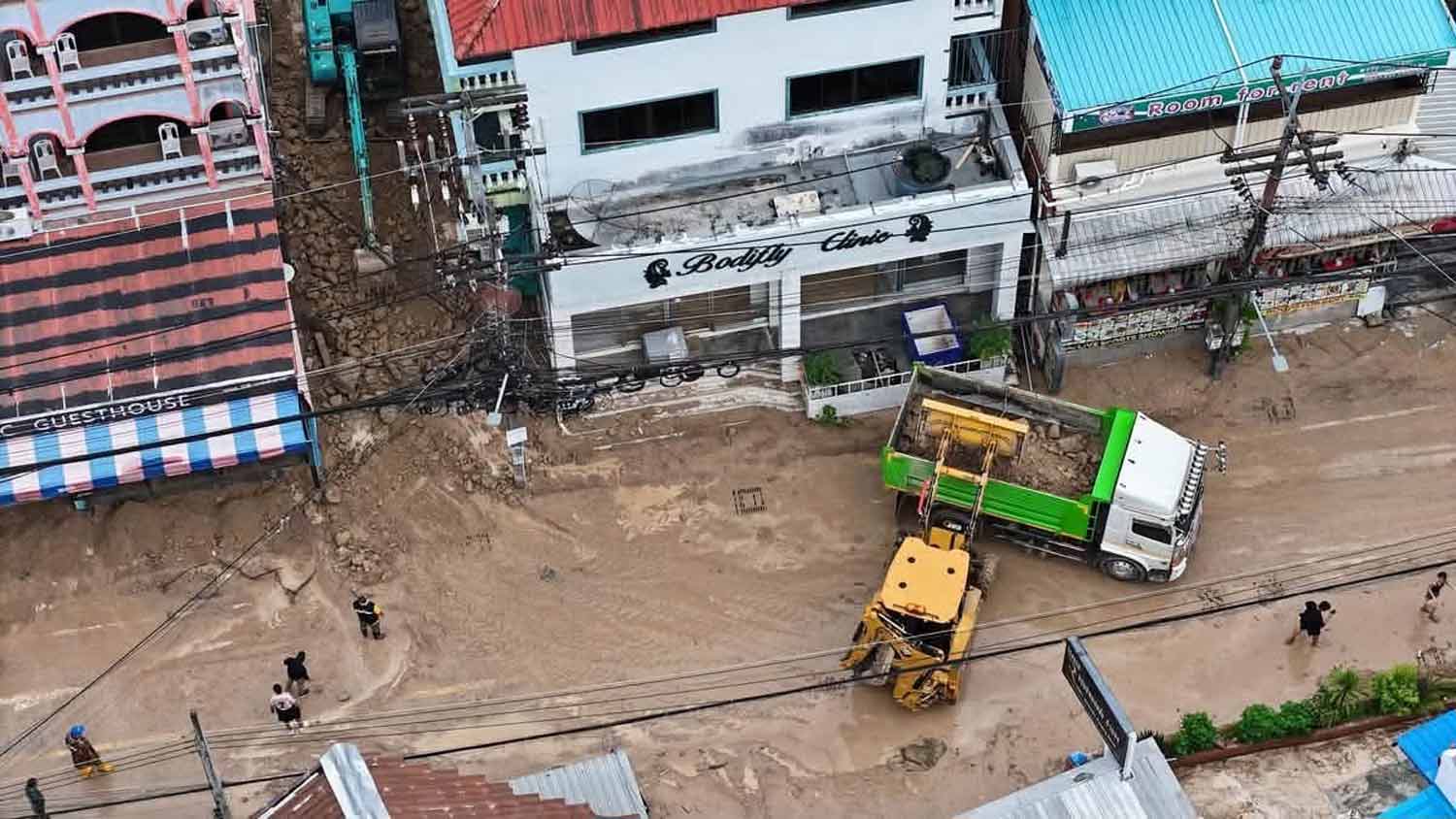 A backhoe and a bulldozer are deployed to remove flood debris on Monday evening.