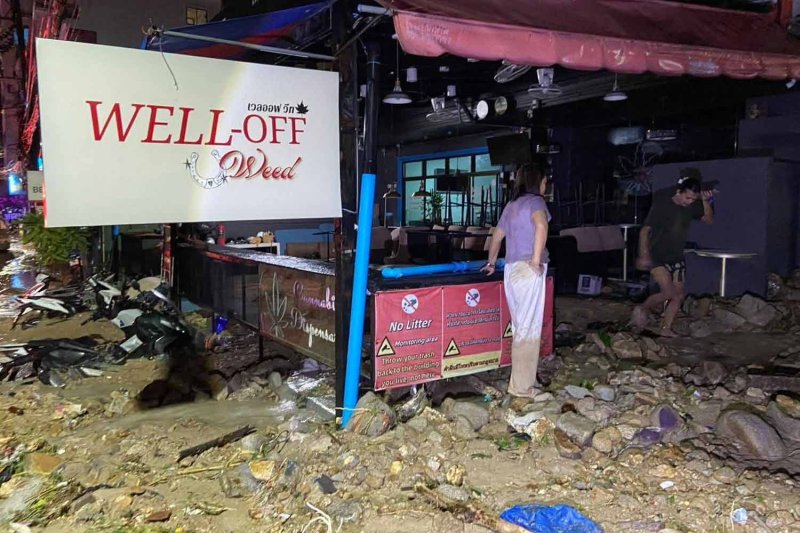 A woman inspects the damage after mud and rocks loosened by heavy rains flowed down into the business district of Patong in Kathu district of Phuket early on Monday morning. (Supplied photo)