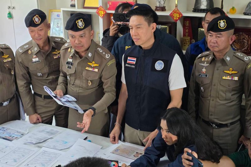 Pol Lt-Gen Noppasin Poolsawat (holding documents), commissioner of the Immigration Bureau, questions suspects in the “fake fathers” scandal on Tuesday. The suspects are accused of helping Chinese families obtain Thai birth certificates through illegal arrangements. (Photo supplied/Wassayos Ngamkham)