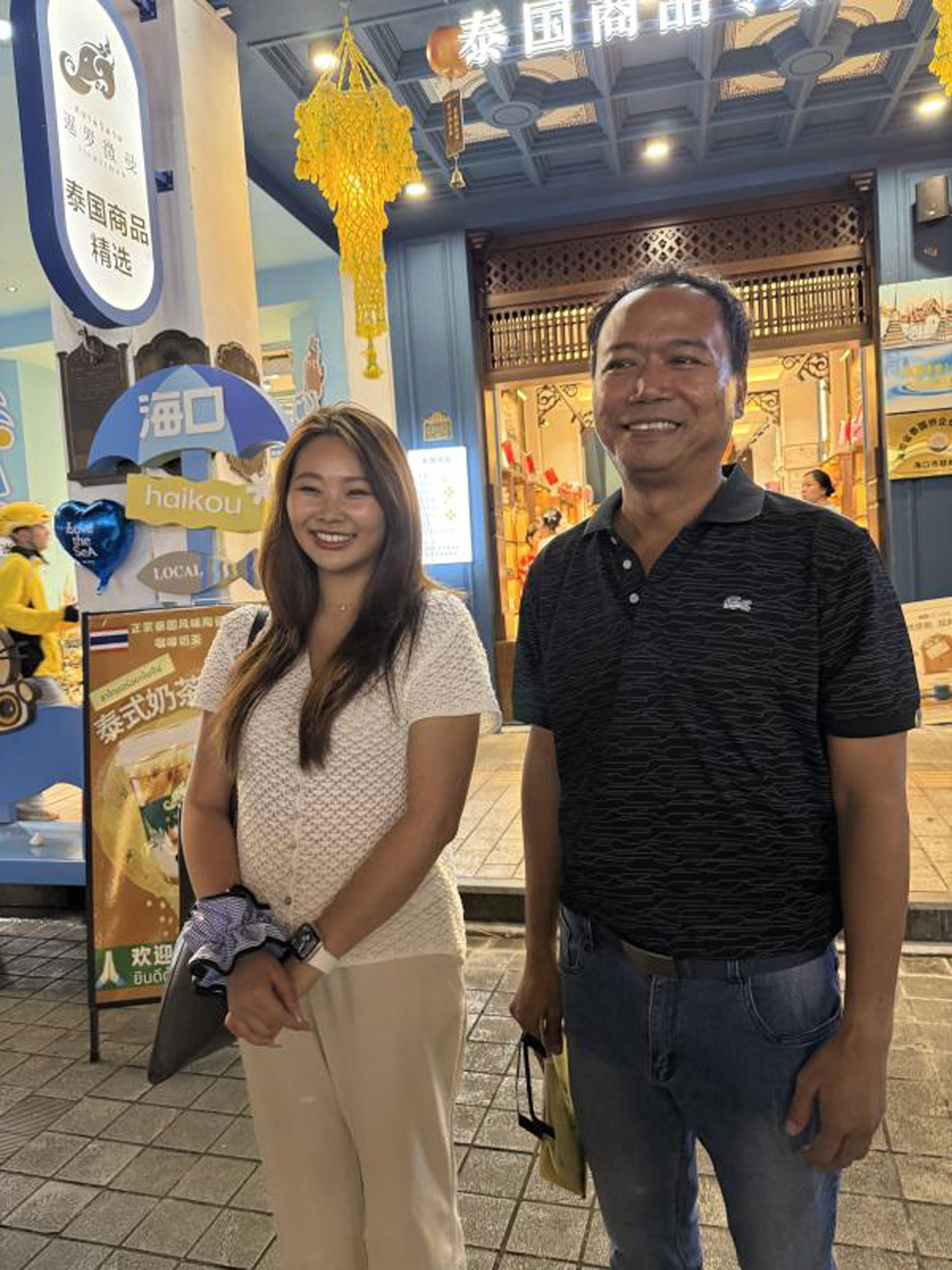 Two Thai businesspeople pose for a photo  in front of Siam Viman, a Thai goods retail shop on  Qilou Old Street. (Photo:  Anucha Charoenpo)