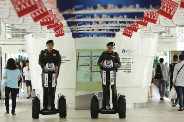 Tourist police patrol the skywalk at Ratchaprasong intersection to ensure safety at tourist spots in Bangkok after a series of bombings in the South last week. PATIPAT JANTHONG