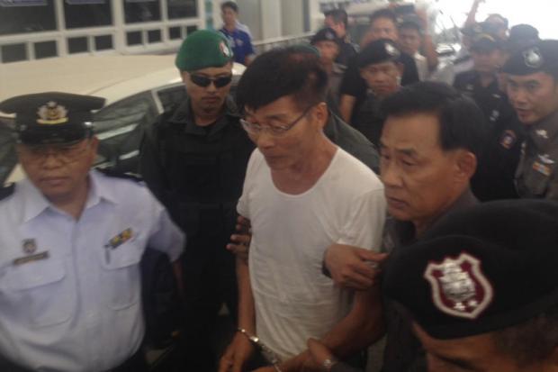 Police escort former doctor Supat Laohawattana after he was extradited from Myanmar yesterday. He fled there to escape the death sentence. Assawin Pinitwong