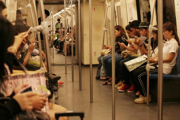 Commuters check mobile devices on a train. The Digital Economy and Society Index will track Thailand's digital progress. APICHIT JINAKUL