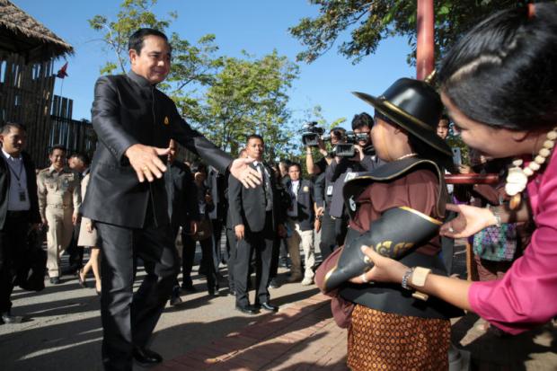 Prime Minister Prayut Chan-o-cha walks toward a boy dressed in traditional costume during his visit to Phra Nakhon Si Ayutthaya historical park in Ayutthaya before chairing the mobile cabinet meeting at Rajabhat University Tuesday. (Photo by Chanat Katanyu)