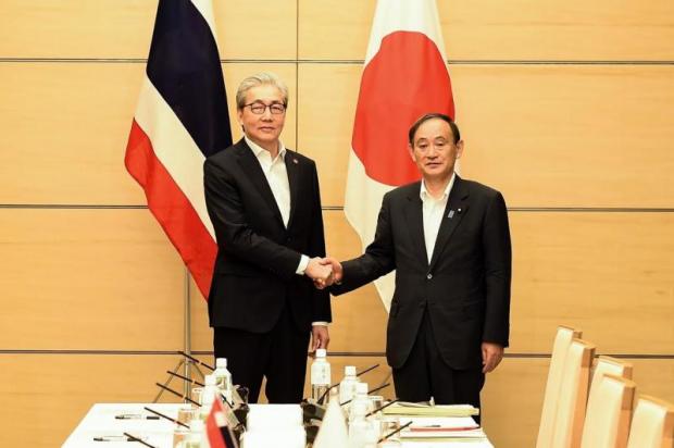 Mr Somkid shakes hands with Yoshihide Suga, Japan's chief cabinet secretary, during Thursday's meeting of high-level officials in Tokyo. Photo courtesy of Government House