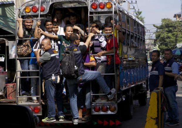 yet more checks: Authorities bring migrant workers they found for further investigation where they were asked to prove their identity and legal working documents. (Photo by Apichit Jinakul)