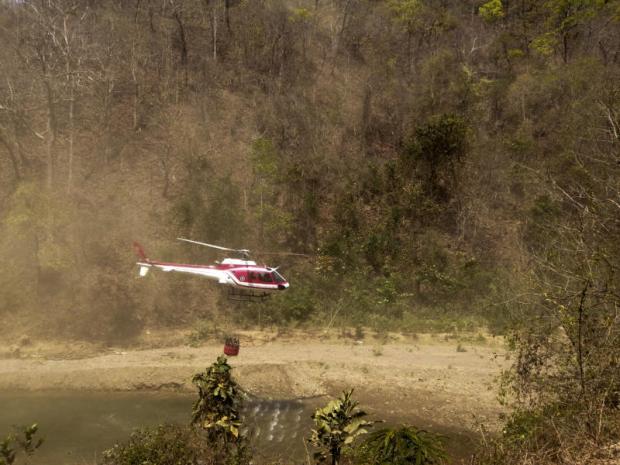 A helicopter airlifts water to fight bush fires in Salawin National Park in Mae Hong Son. Helicopters have made over 100 trips to drop water. Photo courtesy of the Department of National Parks, Wildlife And Plant Conservation