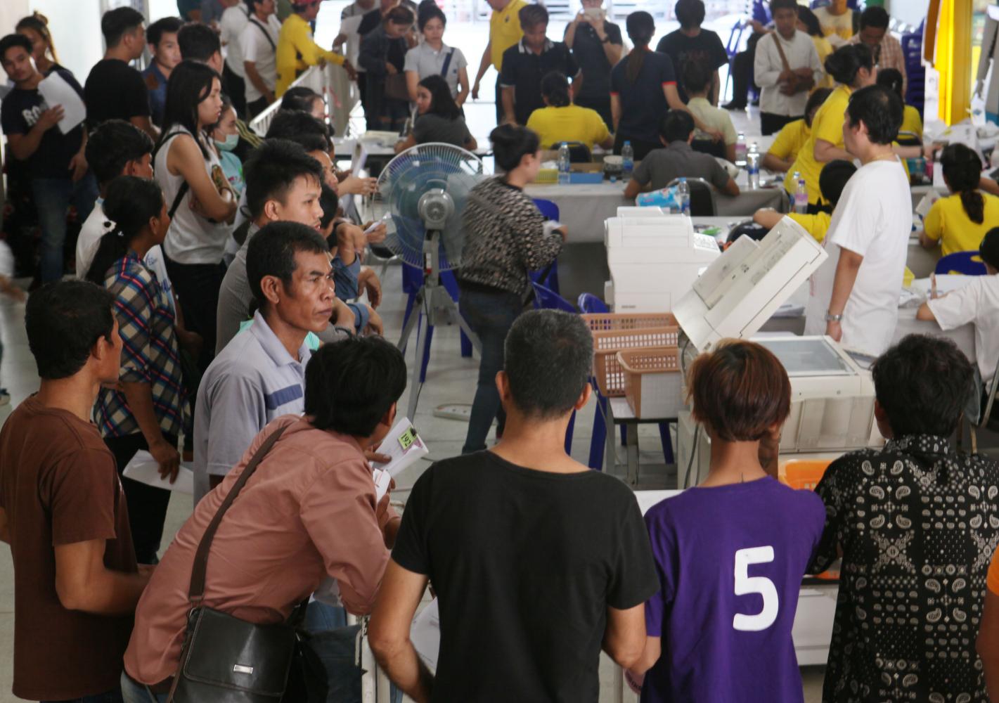 Migrant workers are seen queuing up for work permit registration at the Labour Ministry last year. Apichit Jinakul Migrant workers are seen queuing up for work permit registration at the Labour Ministry last year. Apichit Jinakul