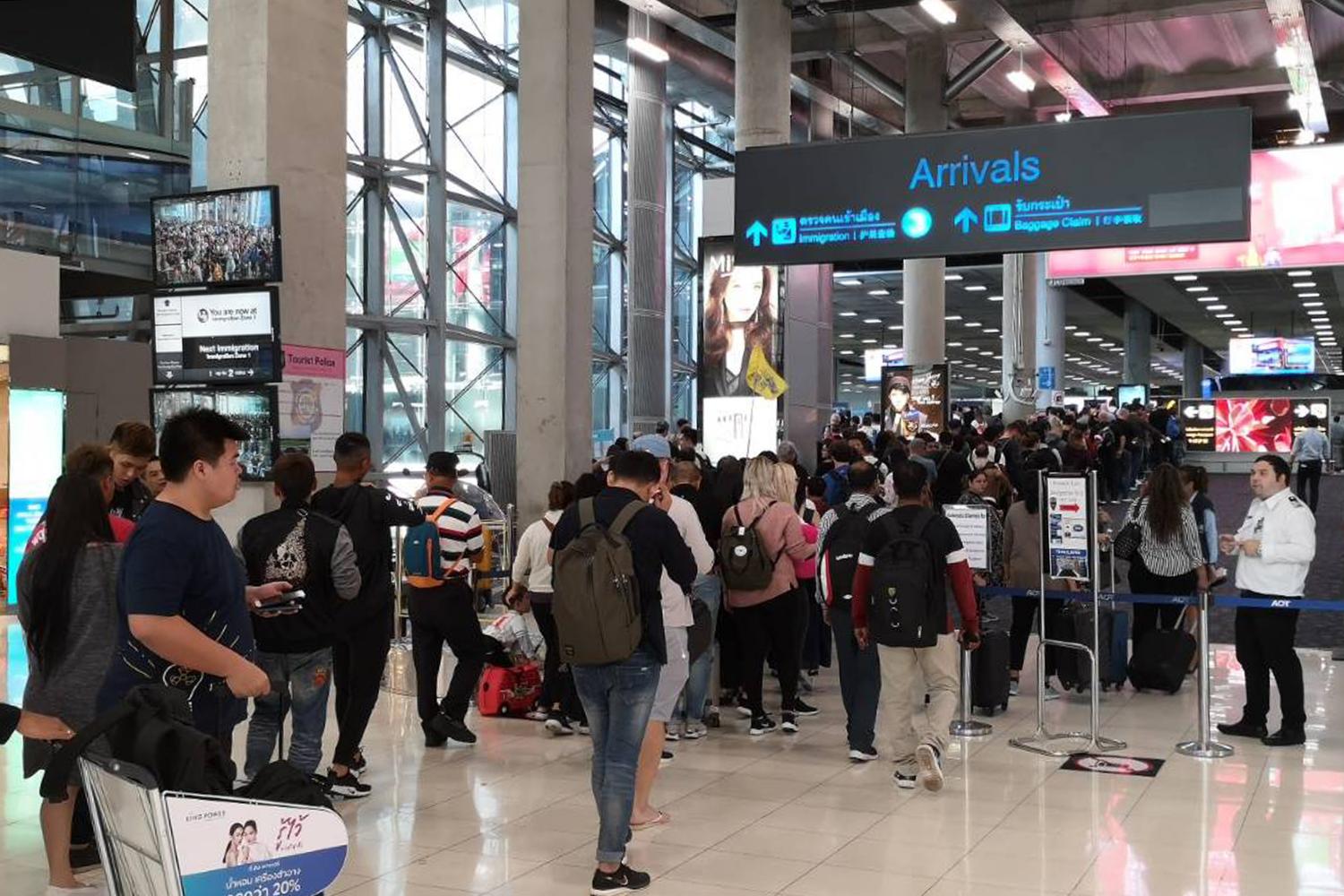 Tourists join the immigration queue upon arrival at Suvarnabhumi airport. The government says the enforcement of TM30 is mainly a national security measure. (Photo by Pattanapong Hirunard)