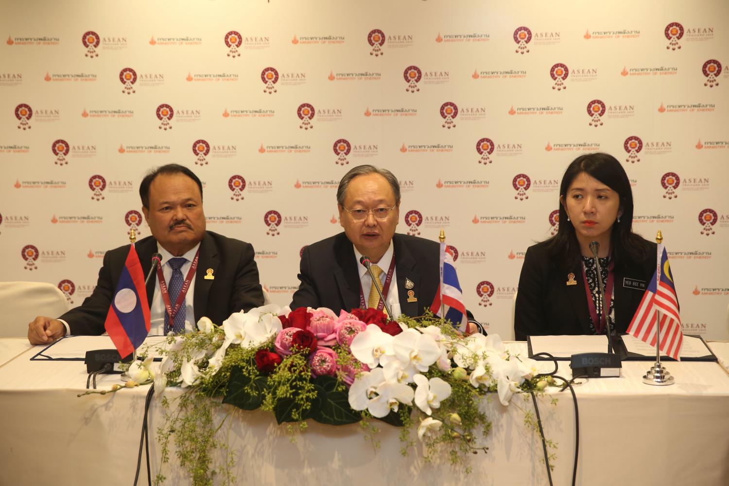 Mr Sontirat (centre) signs the power purchase agreement with Mr Khammany and Mrs Yeo. VARUTH HIRUNYATHEB