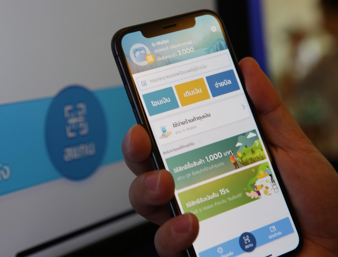 A smartphone user looks at the 1,000 baht cash giveaway on the G-Wallet mobile application. More than 1-million recipients signed up for the cash rebate in less than 14 hours on the first day of registration. (Photo by Apichit Jinakul) A smartphone user looks at the 1,000 baht cash giveaway on the G-Wallet mobile application. More than 1-million recipients signed up for the cash rebate in less than 14 hours on the first day of registration. (Photo by Apichit Jinakul)