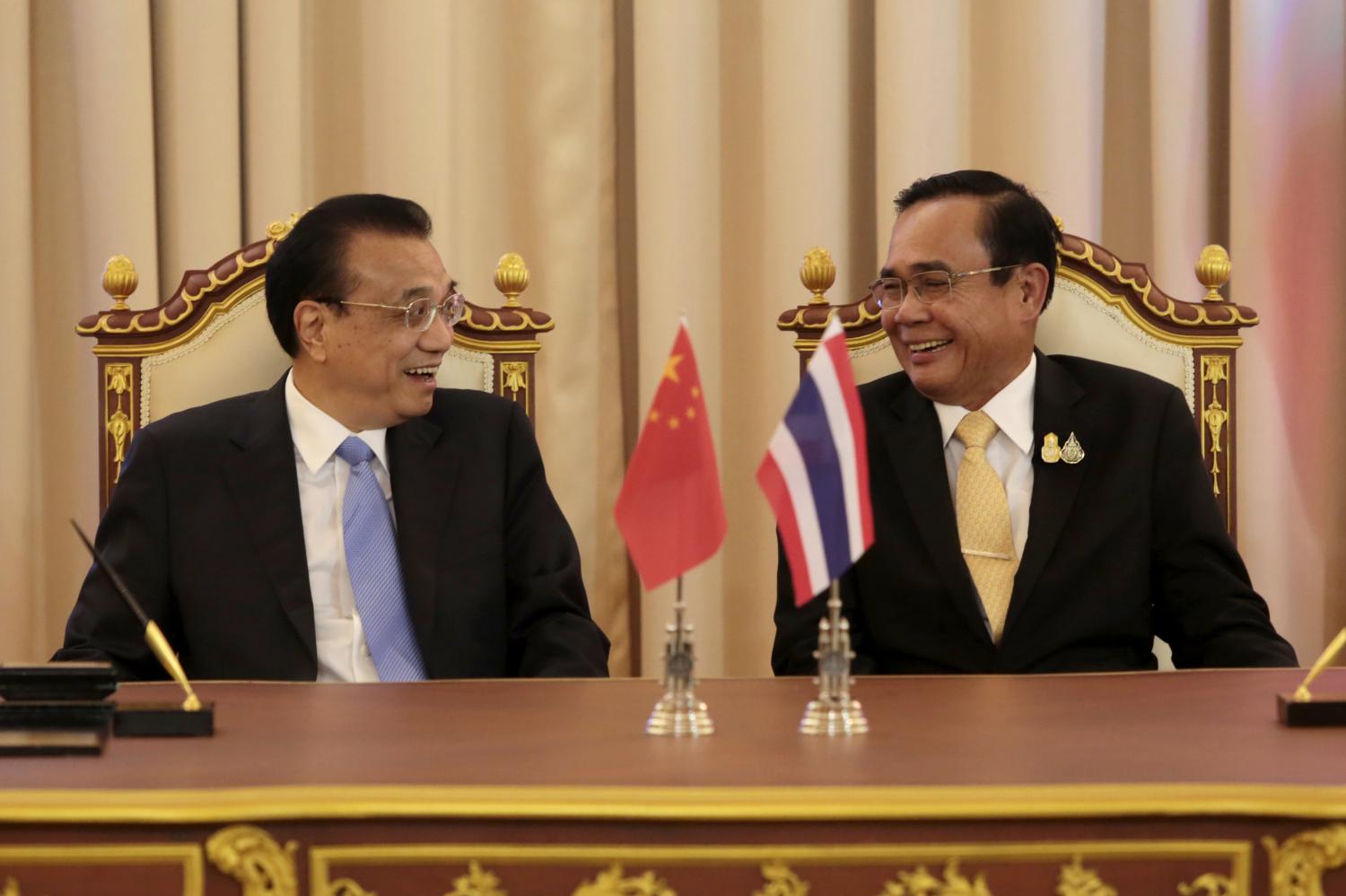 Prime Minister Prayut Chan-o-cha shares a light moment with Chinese Premier Li Keqiang as they witness the signing of three memorandums of understanding on cooperation at Government House on Tuesday. Chanat Katanyu