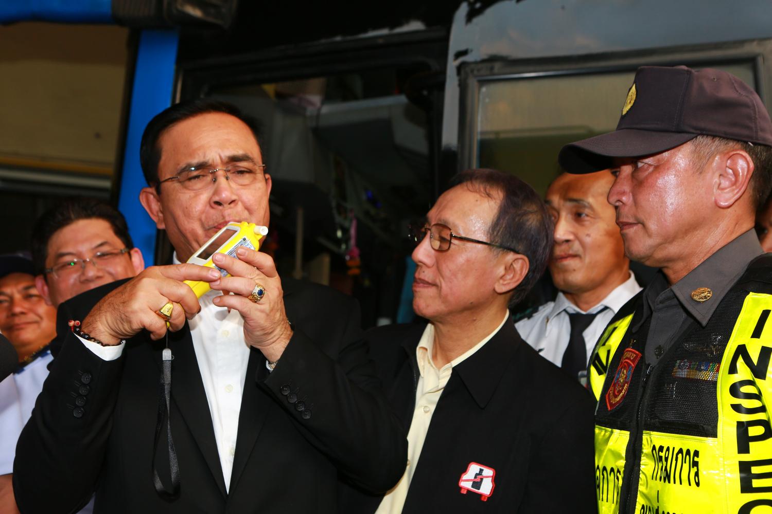 Prime Minister Prayut Chan-o-cha blows into a breathalyser as he kicks off a road safety campaign at Bangkok's Mor Chit bus terminal on Thursday. (Photo by Somchai Poomlard)