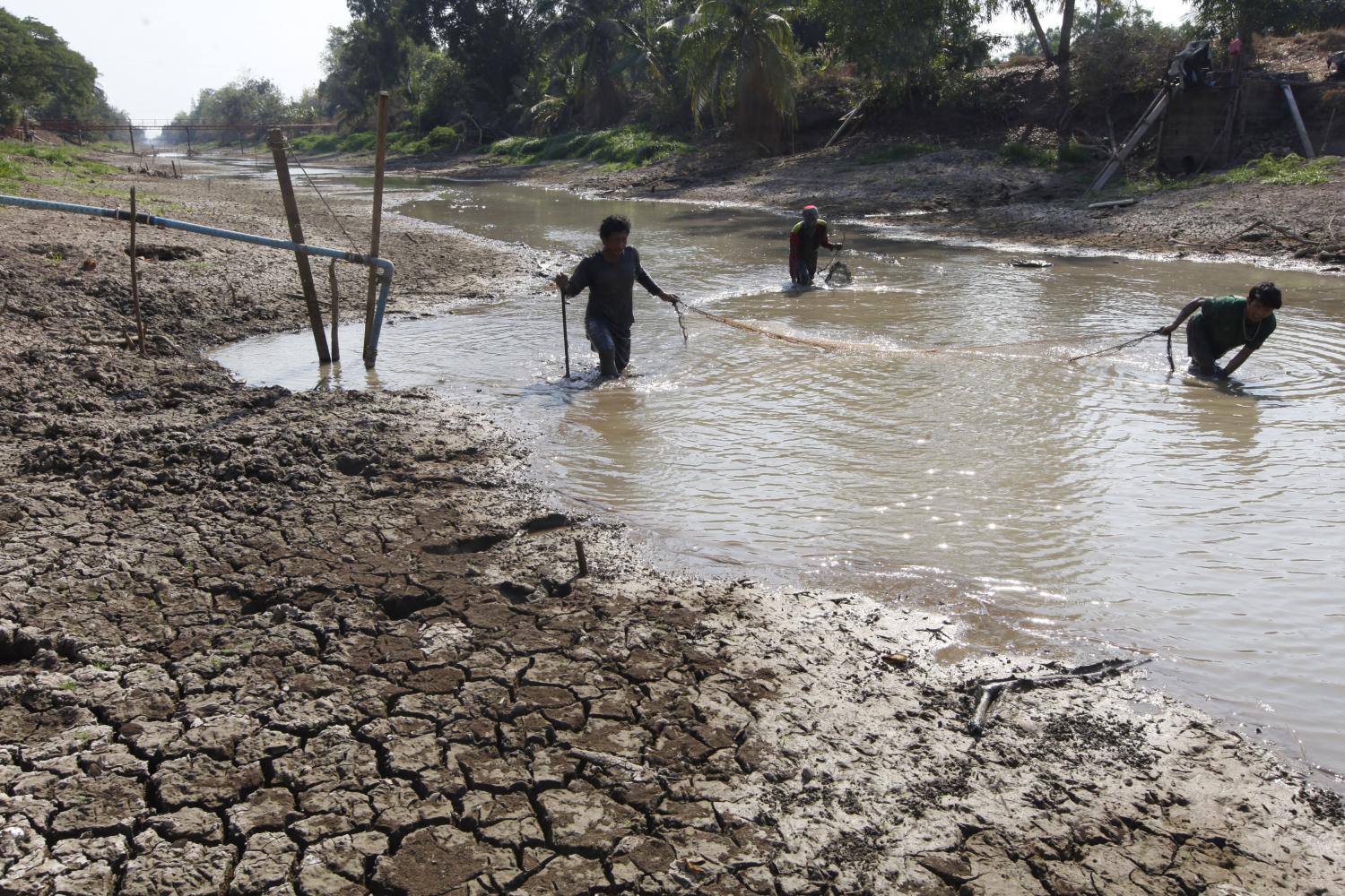 Villagers fish in a pond in Pathum Thani, which has shrunk in size as Thailand braces for its worst drought in four decades. (Photo by Wichan Charoenkiatpakul)