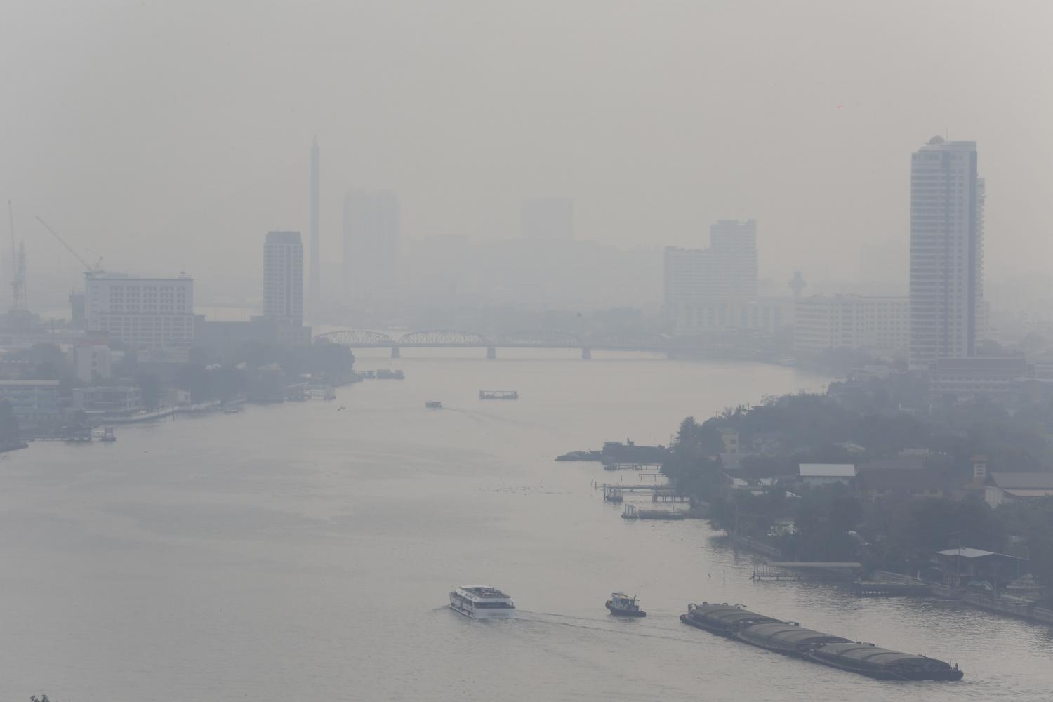 The Chao Phraya River is blanketed with thick haze on Monday as hazardous ultra-fine dust levels in the air exceeded so-called safe levels in many parts of Bangkok. Residents were warned to wear masks outdoors. (Photo by Pornprom Satrabhaya)